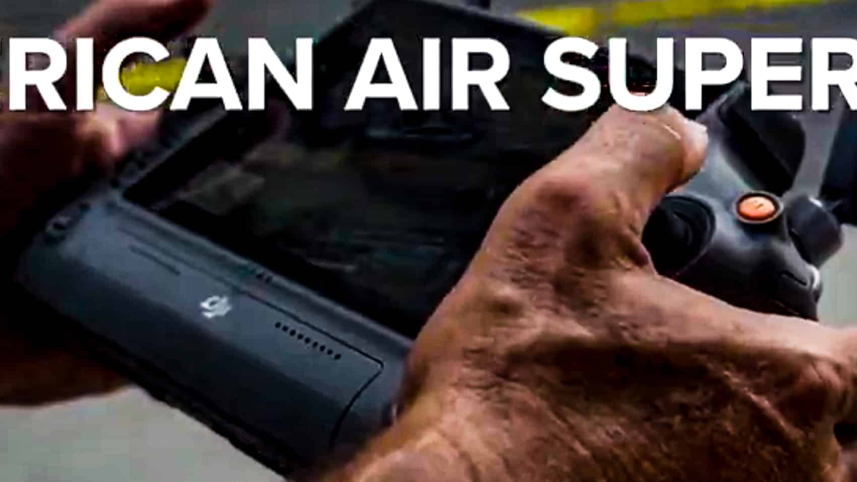 Hands on a DJI controller beneath a DHS video caption about air superiority.