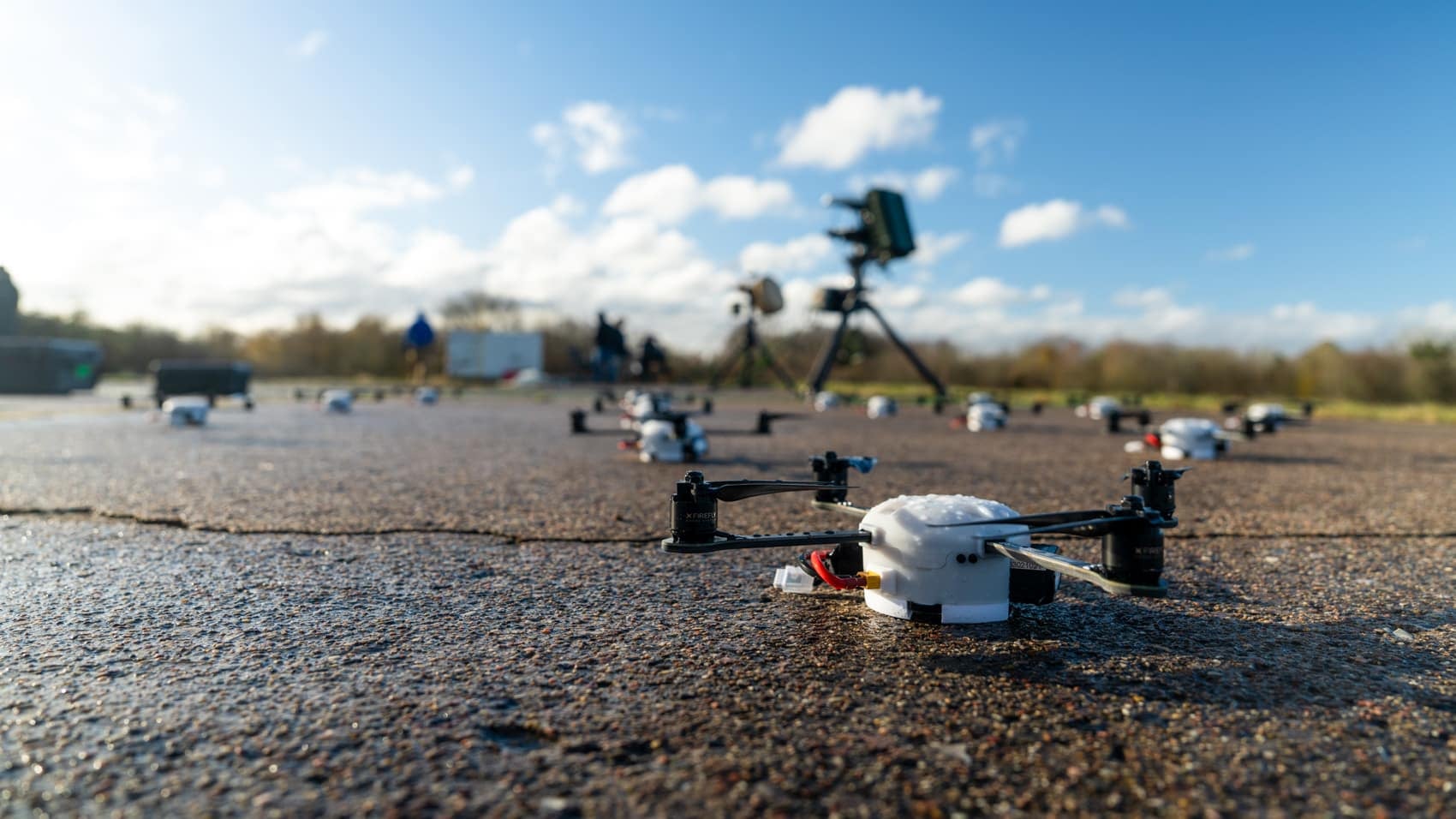 Small drones and sensor tripods lined up on the apron during Project Flytrap.