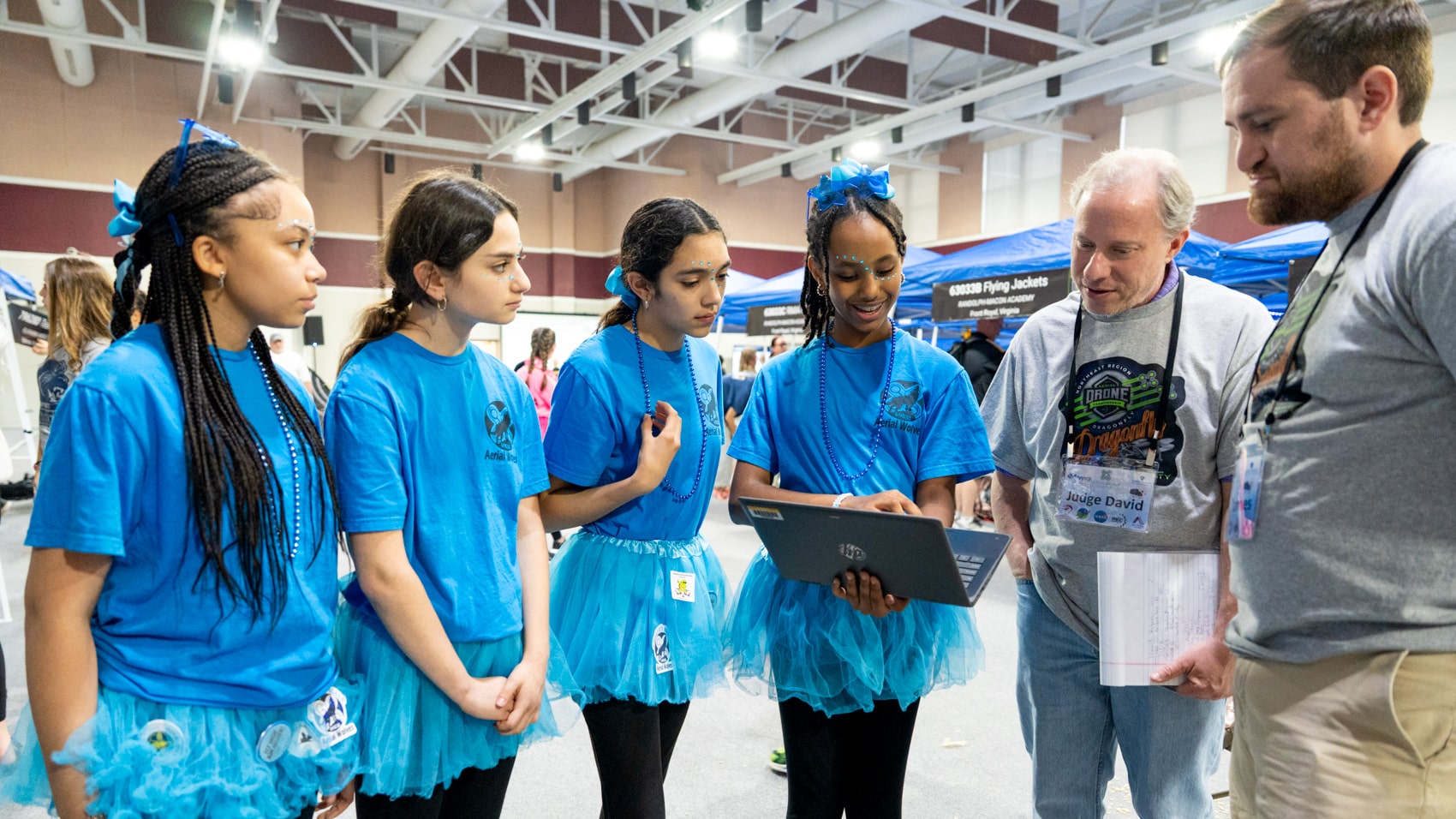 Students explaining their drone and programming logic to competition judges.