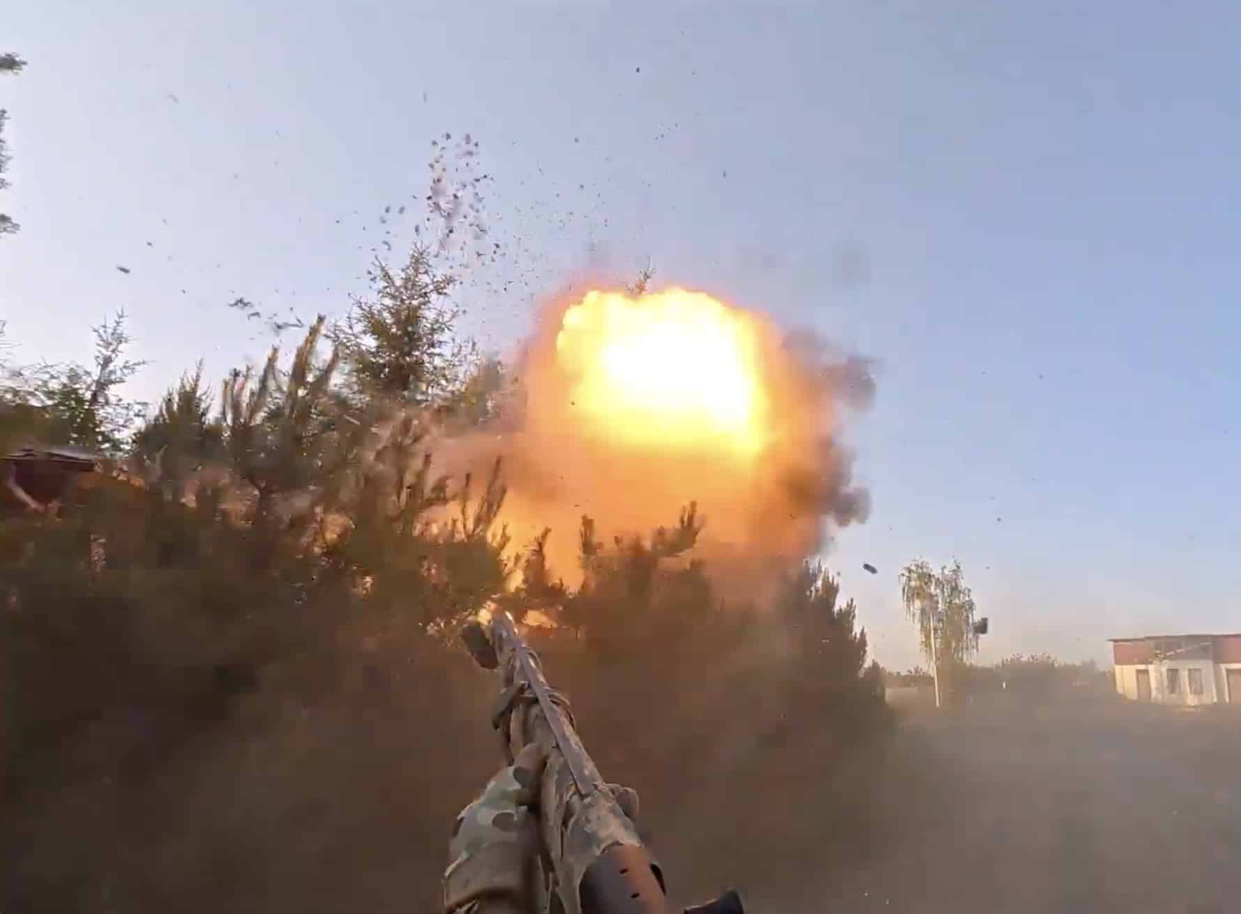 First-person view of a shotgun raised as an explosion erupts ahead.