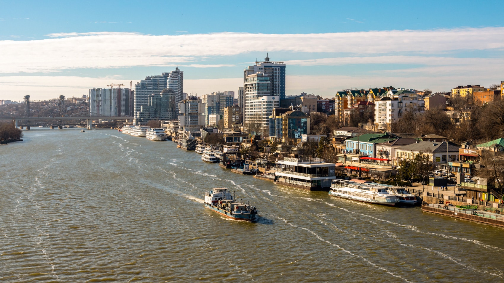 Aerial view of the Rostov-on-Don riverfront with moored boats and high-rises.