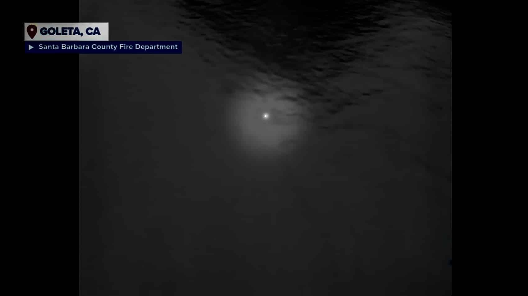 Thermal drone view in which a small white spot marks the surfer's head.