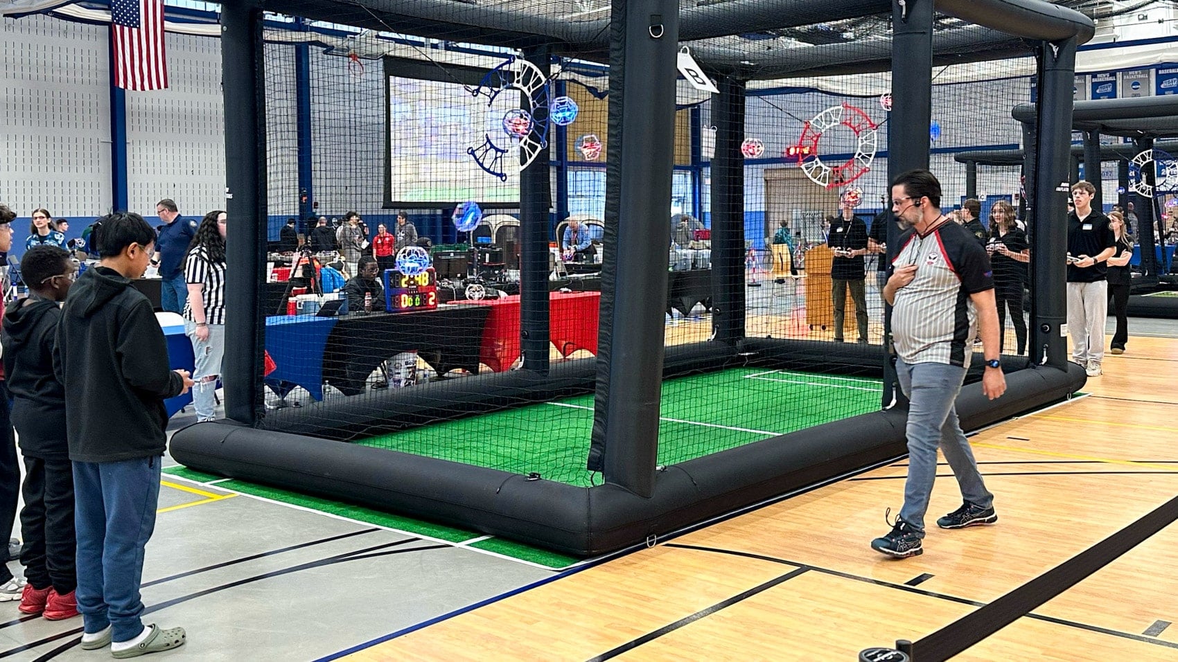 A striker drone flying toward the goal ring suspended in midair.