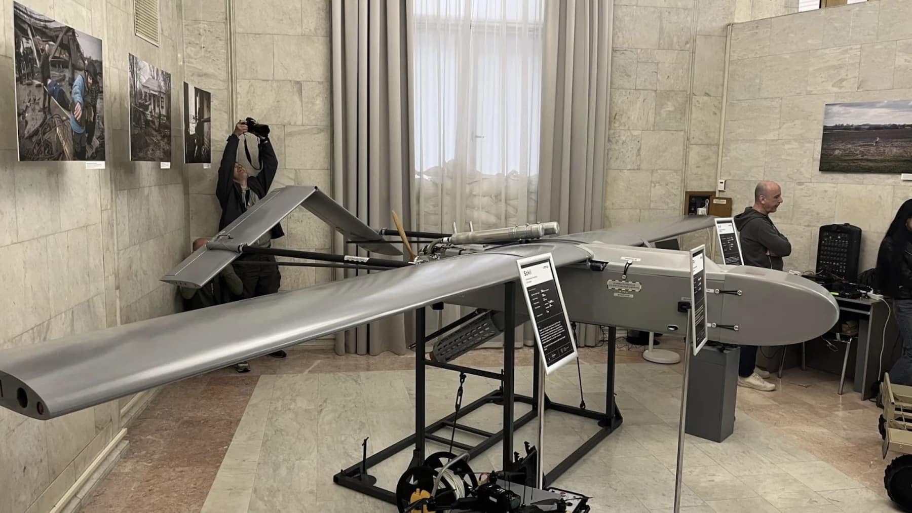 FirePoint strike drone displayed on a stand in a marble-walled hall.