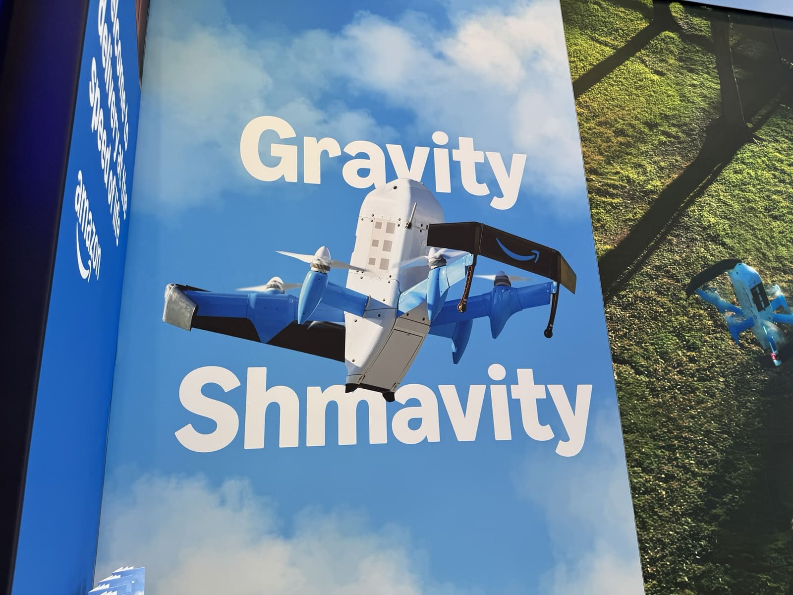 Amazon's trade show banner reading Gravity Shmavity beside an illustration of the MK30 delivery drone