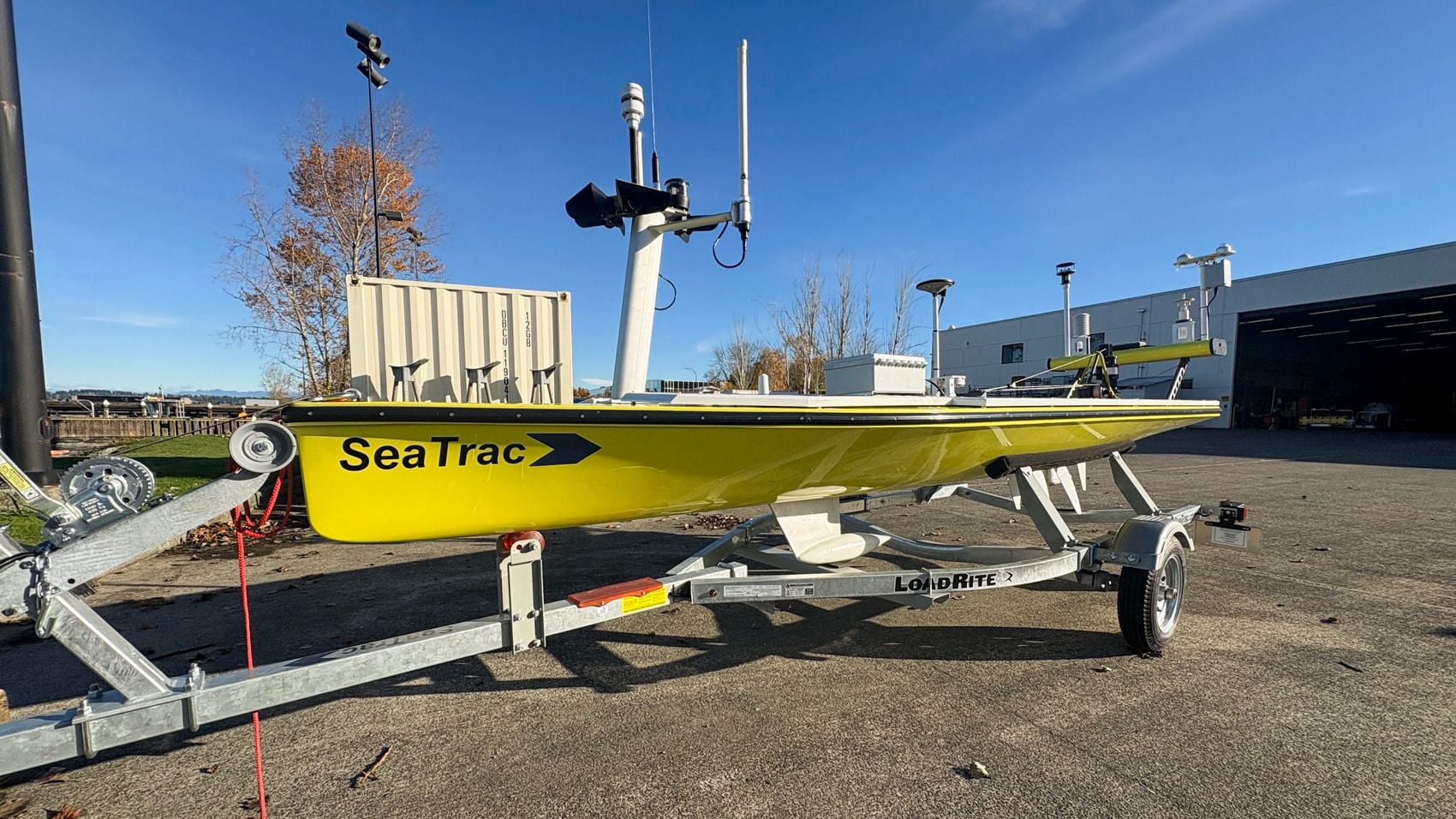 The yellow SeaTrac SP-48 sits on its road trailer outside a NOAA facility.