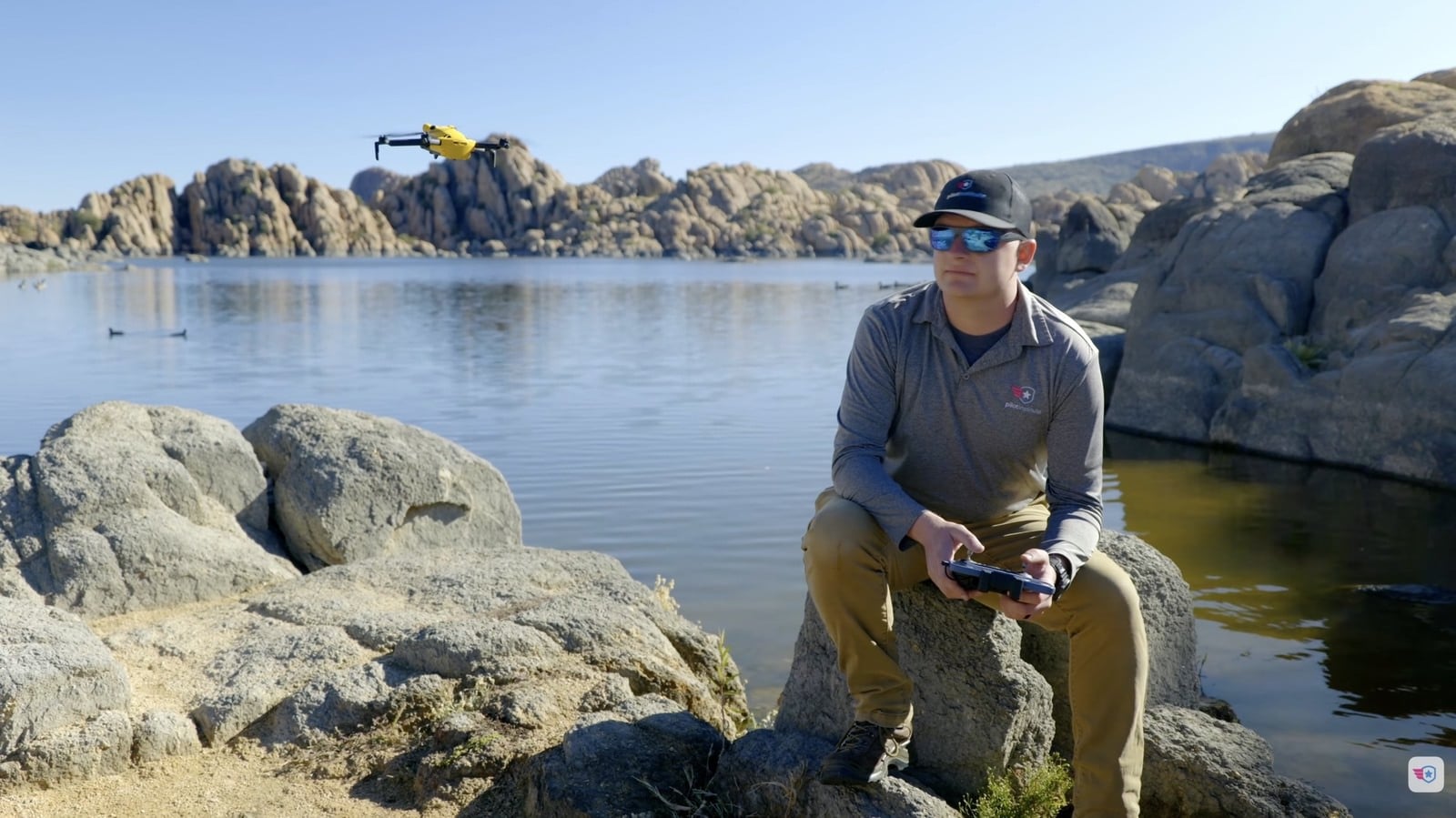 Greg Reverdiau flies from a rocky shoreline as his drone crosses the water.