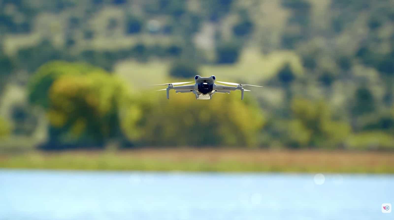 A compact drone hovers low above a lake during the Pilot Institute demonstration.