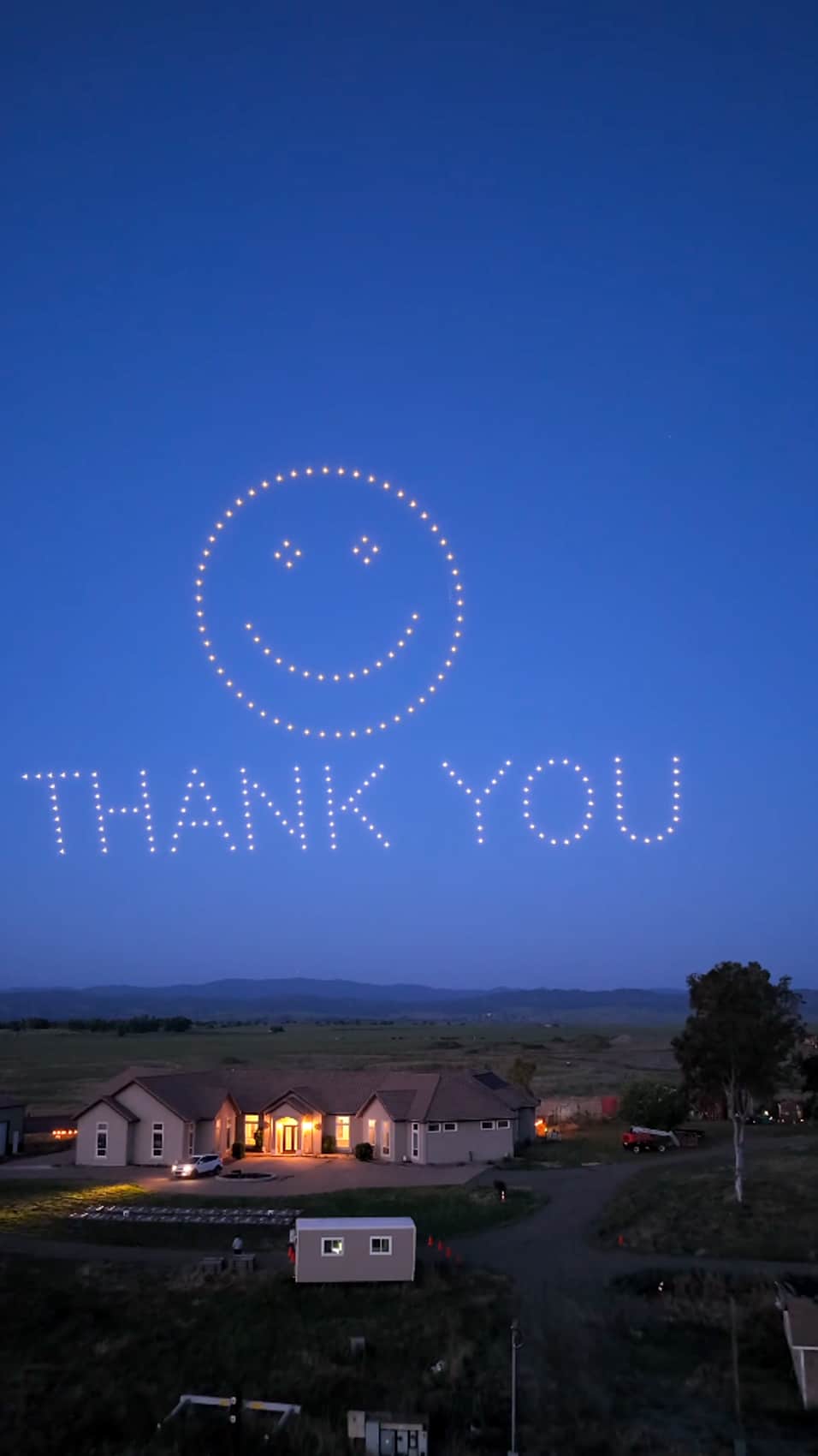 The drone swarm closes with a smiley face and THANK YOU over the house.