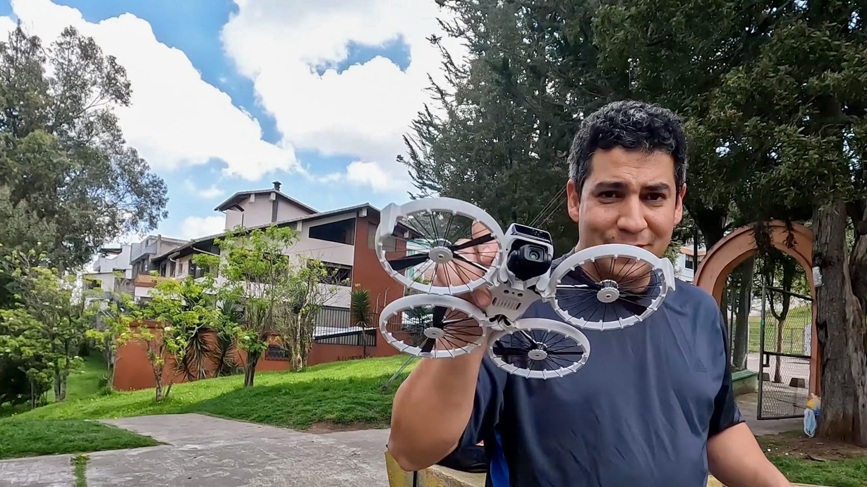 A pilot holds a DJI Flip with its propeller guards facing the camera outdoors.