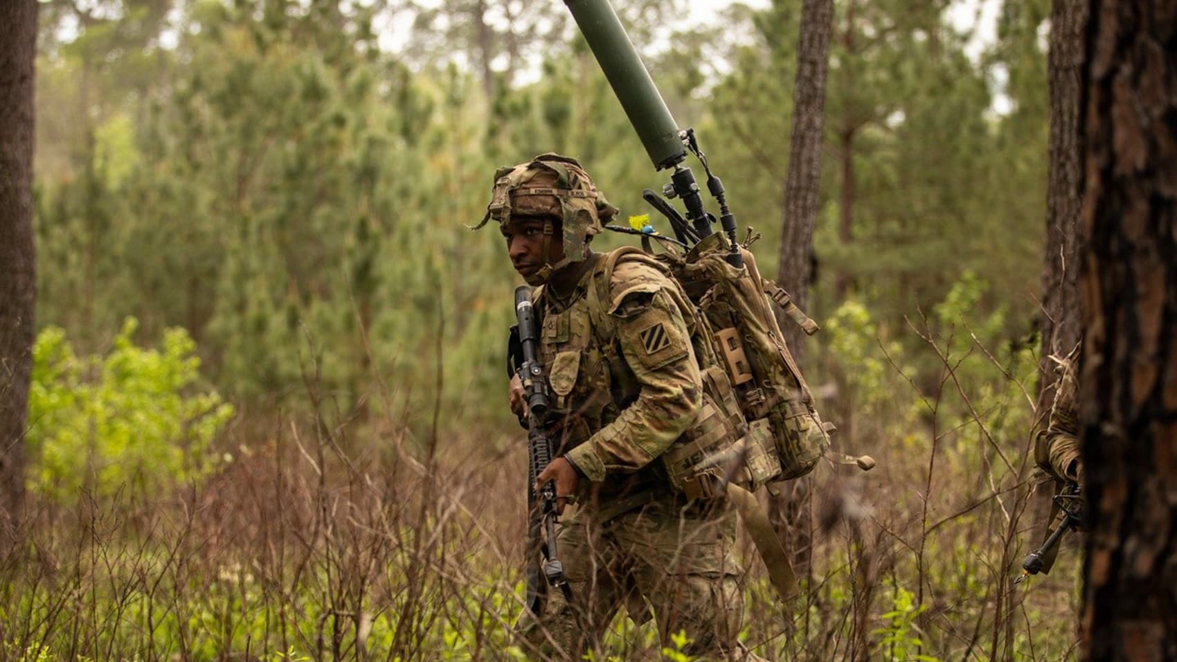 A dismounted Soldier carries the Terrestrial Layered System Manpack for signal intercept and jamming.