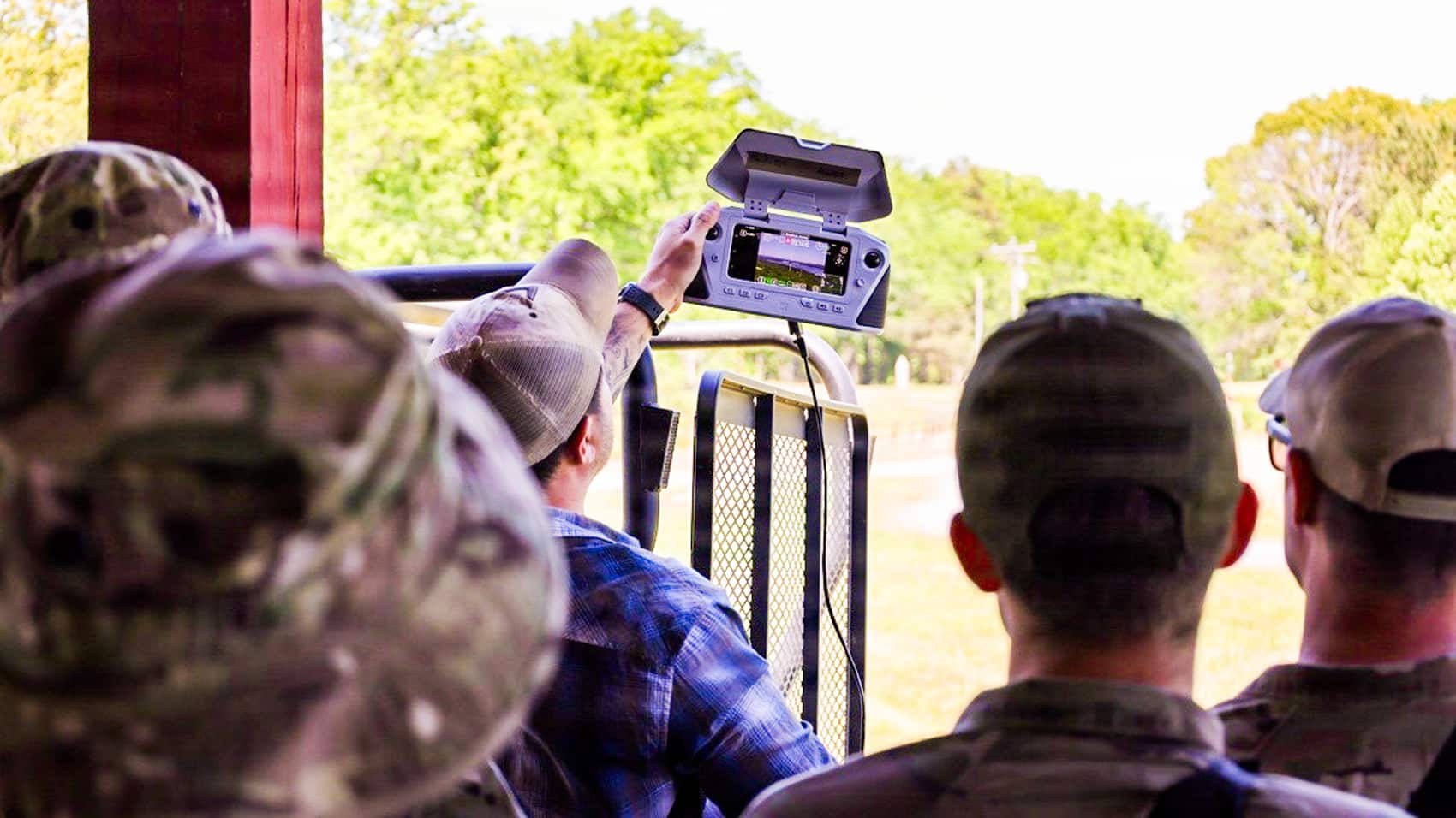 Artillerymen of the 5-113th Field Artillery watching the aerial feed.
