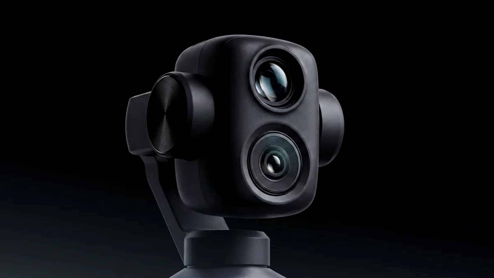 Dual-lens gimbal camera mounted on its handle body, lit from the side.