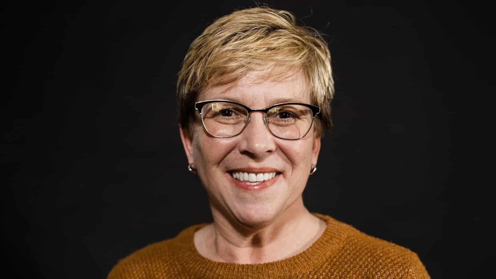 Council member Emily Benedict in a portrait against a dark studio backdrop.