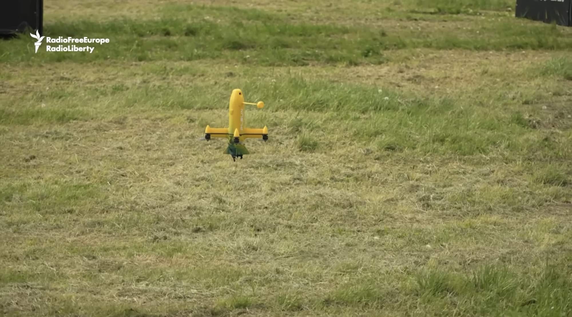 Small yellow model aircraft parked on grass at a Ukrainian drone competition.