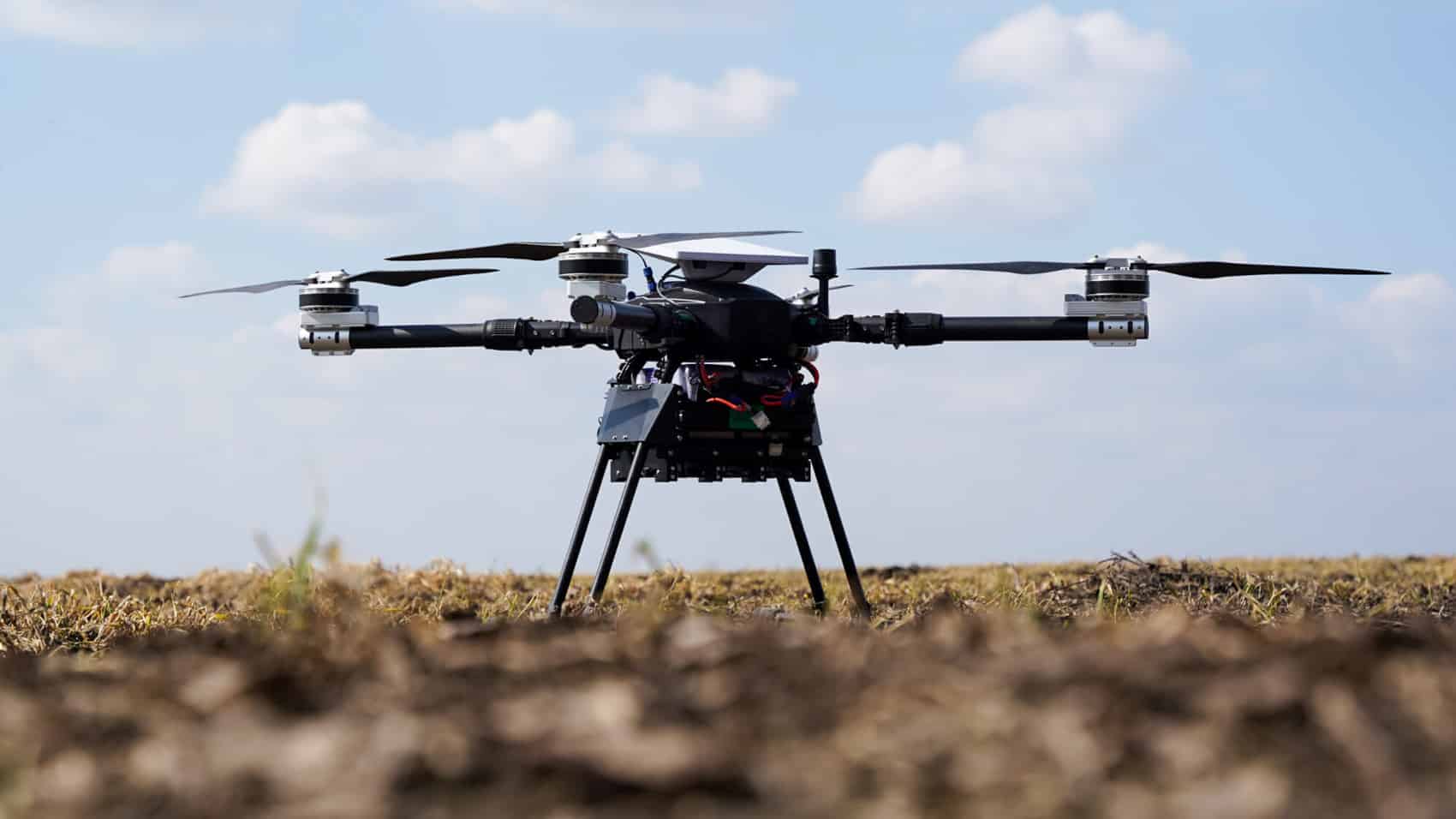 Adis heavy bomber quadcopter standing on grass under an open sky.