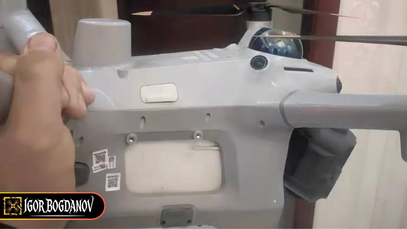 Side view of the purported DJI Matrice 5 held in hand, showing the dome-shaped LiDAR module and a cylindrical antenna on the top deck