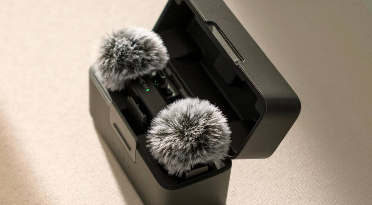 DJI Mic Mini transmitters with furry windscreens sitting in their charging case