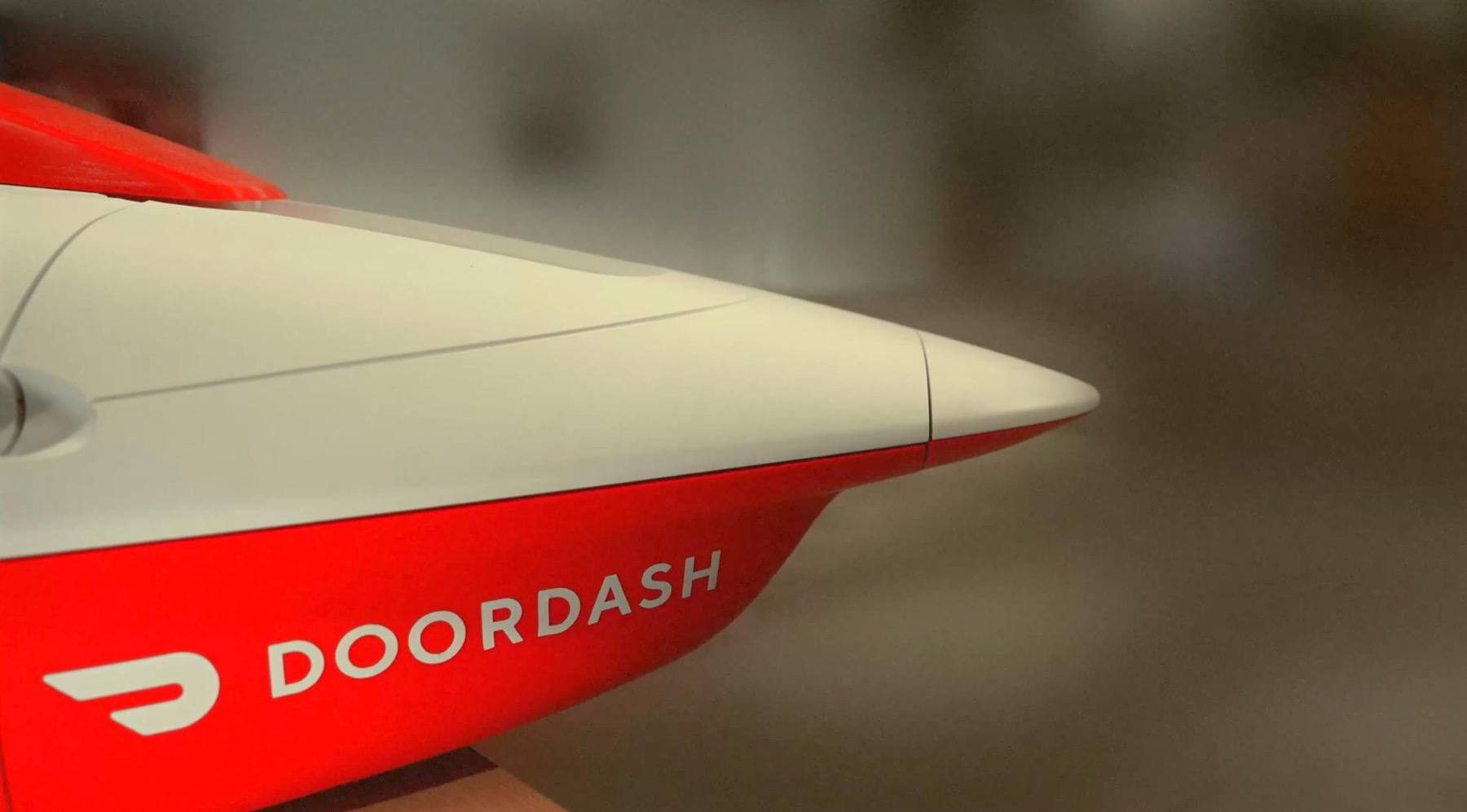 Close-up of the streamlined red and white DoorDash Air delivery drone body showing the DoorDash name and logo
