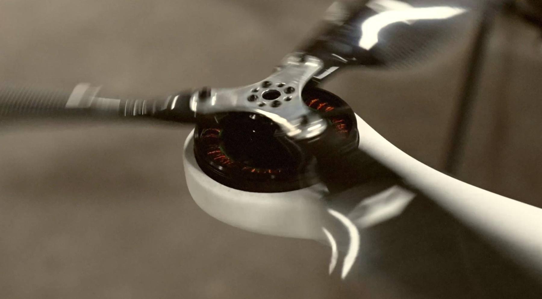 Close-up of an electric drone motor driving a rapidly spinning propeller during development testing