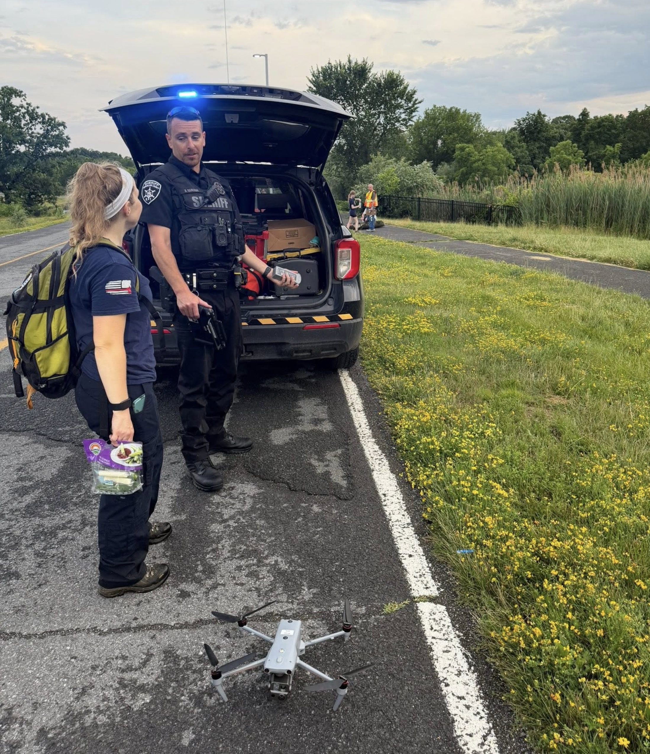 Rensselaer County Sheriff's deputy at a search scene with an Autel EVO Max-series drone staged on the pavement