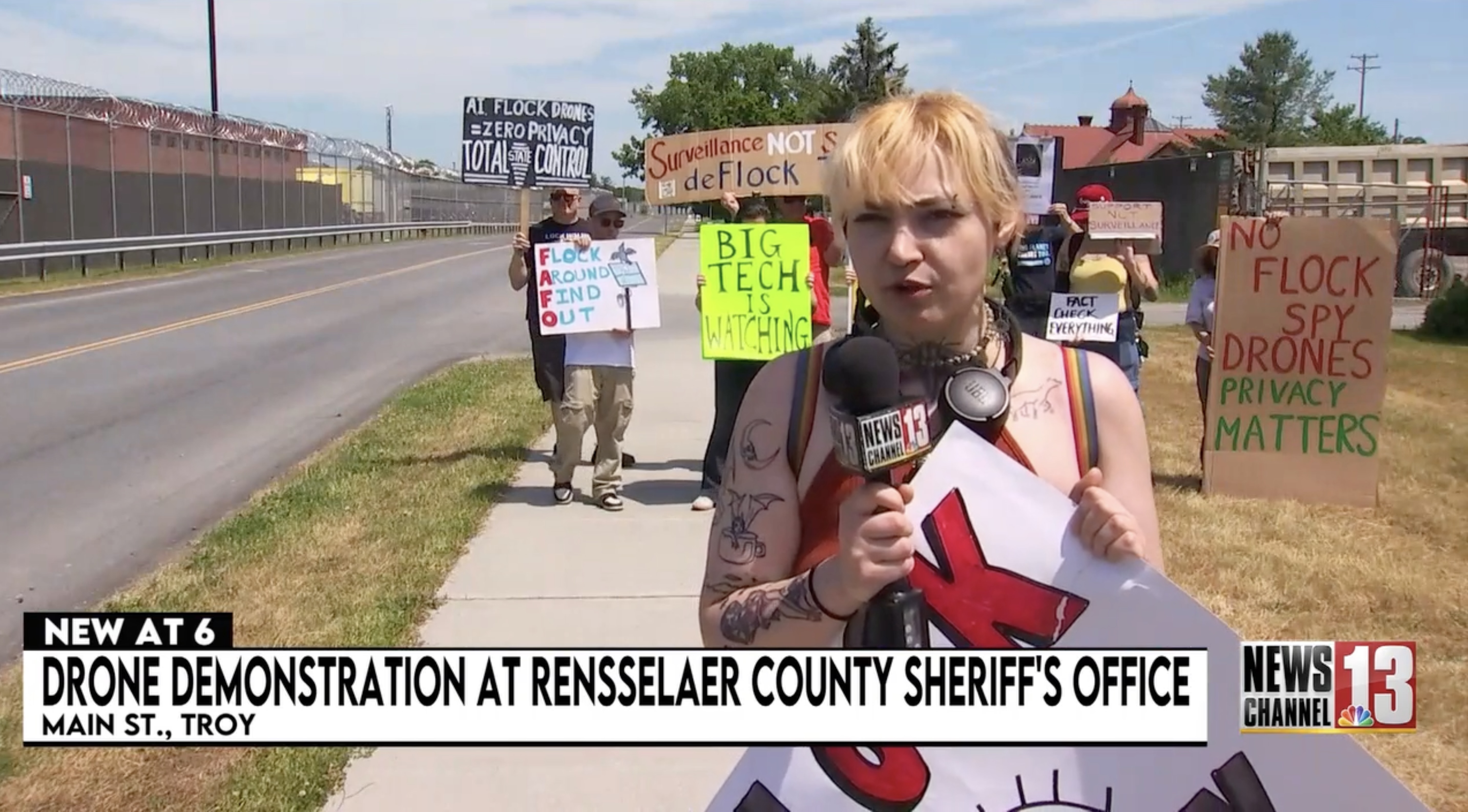 DeFlock Troy protesters holding signs outside the Rensselaer County Sheriff's Office