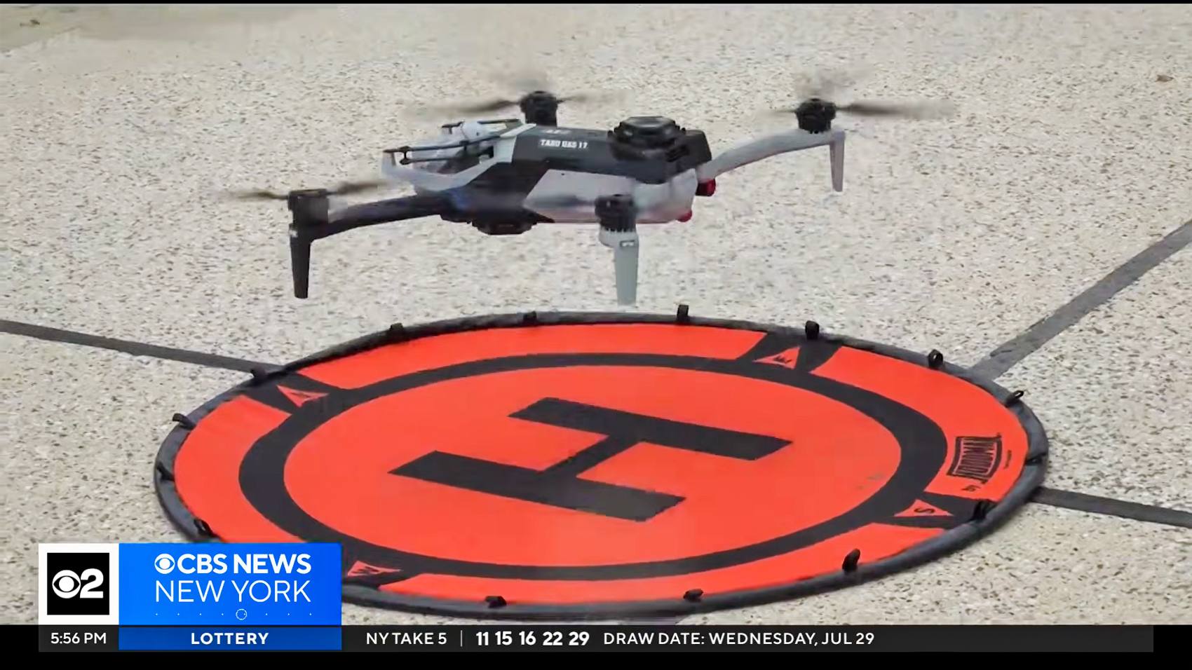 A quadcopter hovering above an orange landing pad during an NYPD beach patrol