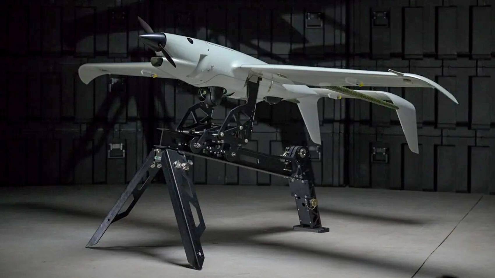 Skyeton Raybird drone displayed on a launcher inside a dark hangar