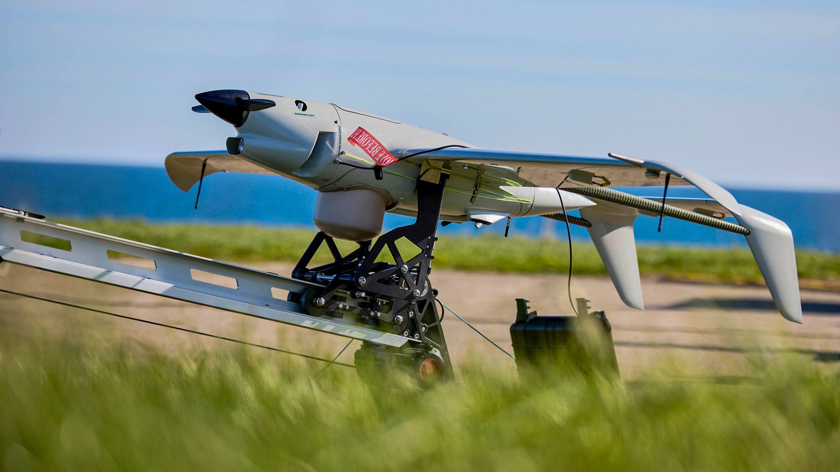 Skyeton Raybird drone with an RF locator payload mounted on a coastal launch rail