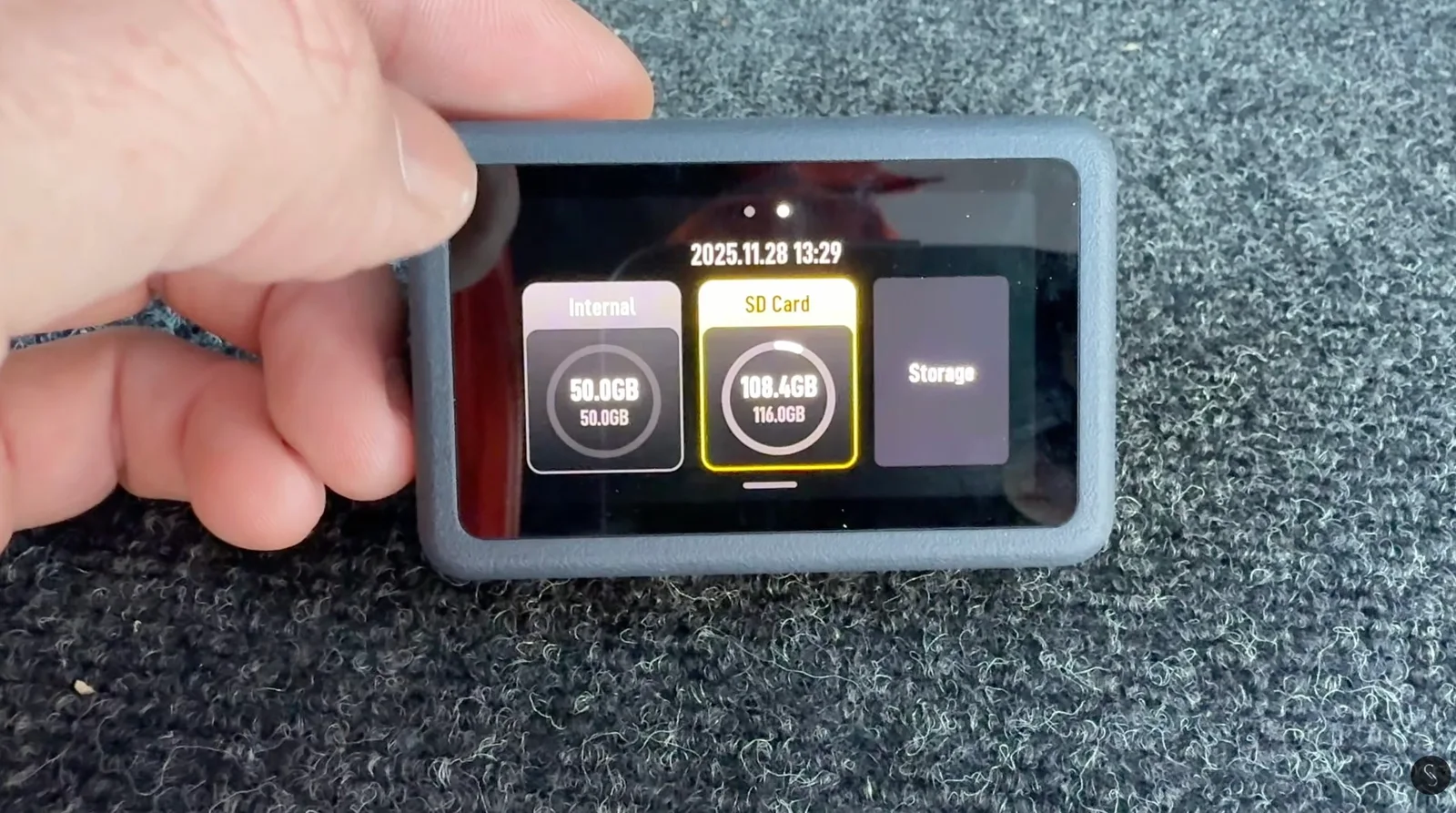 Hand holding the DJI Osmo Nano Vision Dock showing the storage menu with 50.0GB internal memory and a 108.4GB free of 116.0GB microSD card
