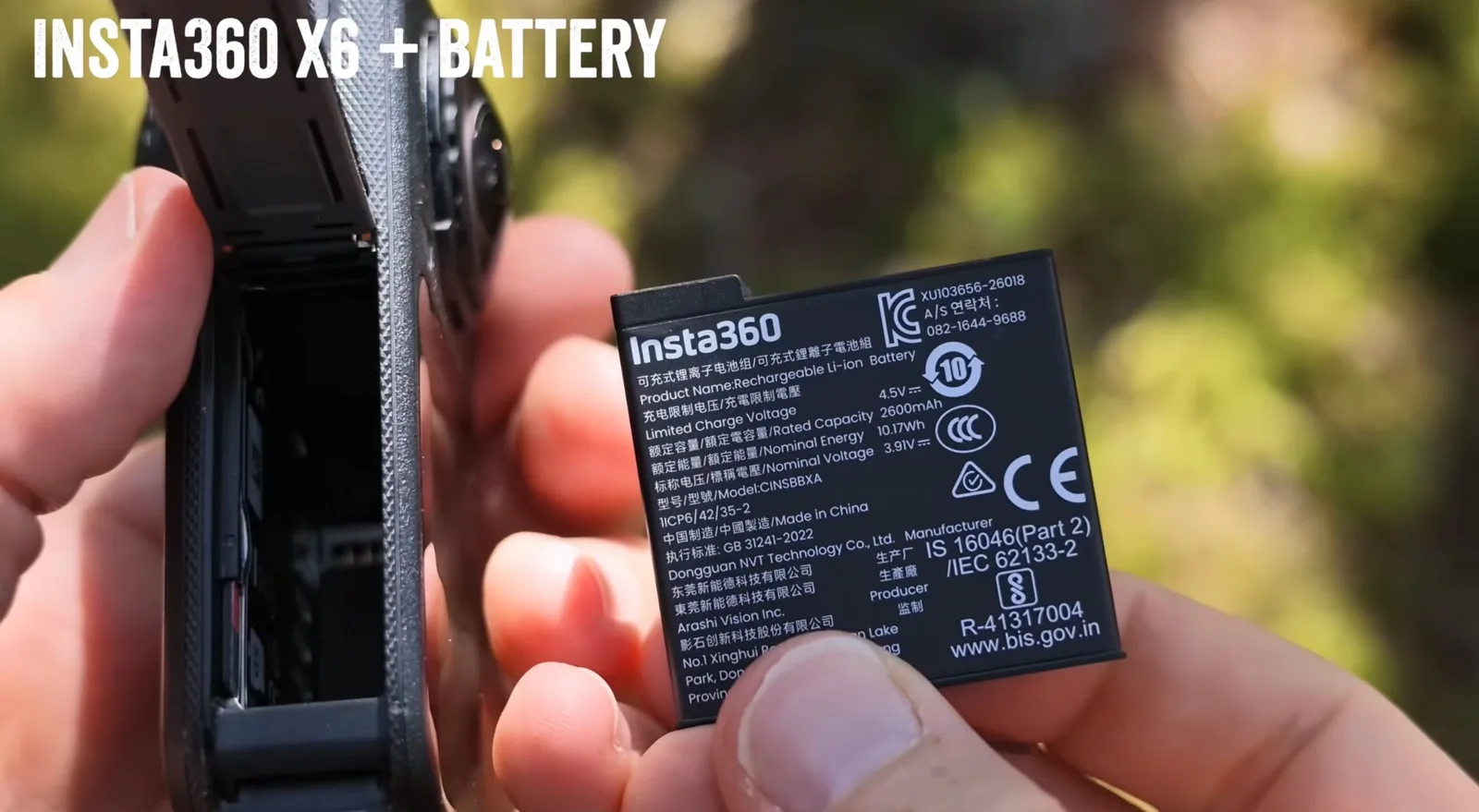Hand holding an Insta360 X6 camera with its battery door open next to the removed 2600mAh Li-ion battery pack