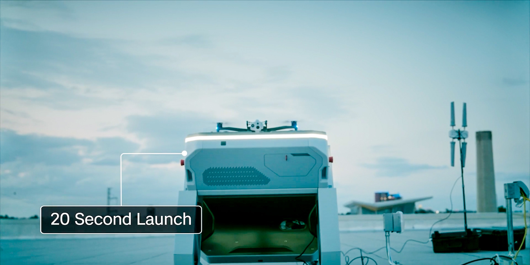 A white Skydio dock sits open on a rooftop at dusk with a drone on its launch pad, labeled with a 20 Second Launch callout.