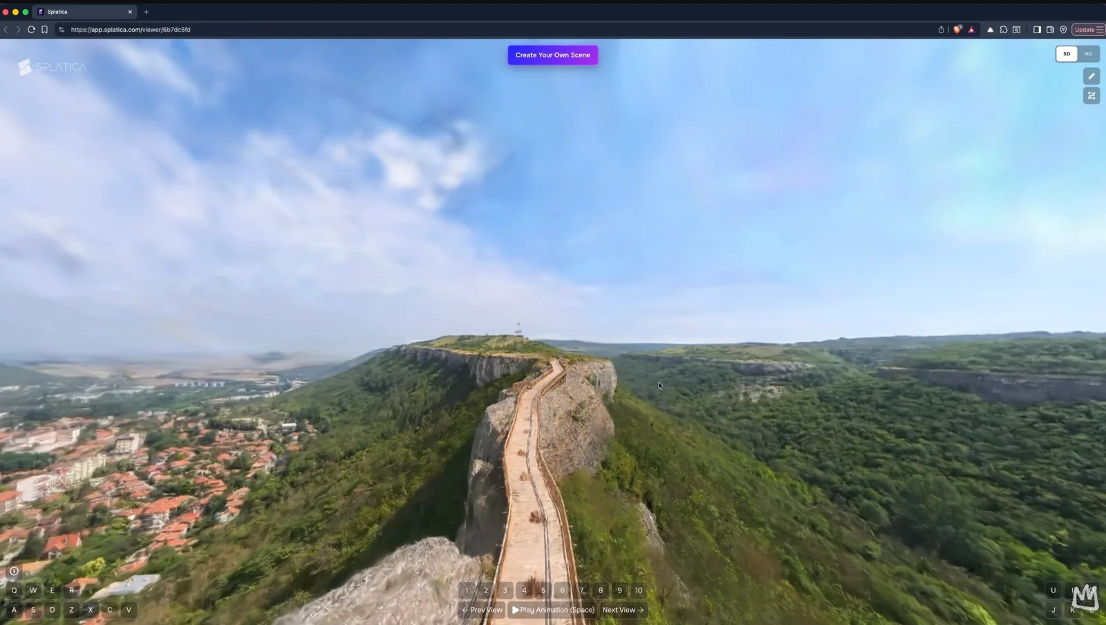 Splatica web viewer showing a 3D Gaussian splat reconstruction of a clifftop fortress with a stone walkway ridge above a red-roofed town and green valley