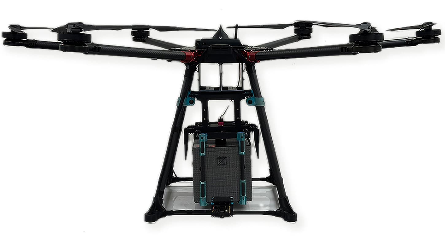 The Valqari VQ1600 delivery drone, an eight-rotor carbon-fiber airframe carrying a gray insulated specimen box in its cargo cradle