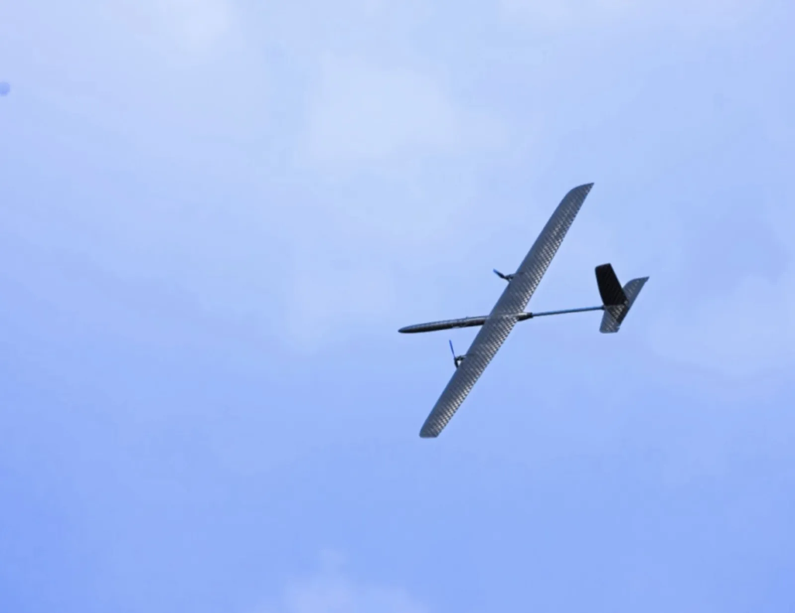 Alteon fixed-wing autonomous aircraft in flight against a blue sky