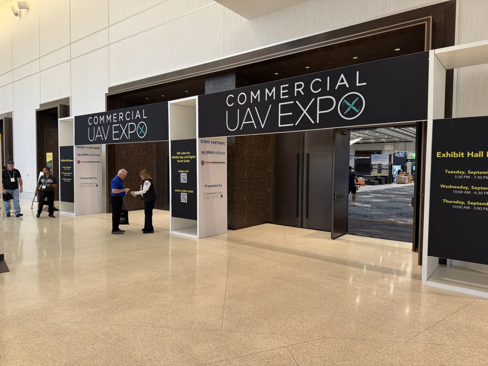 The Commercial UAV Expo 2026 entrance at Caesars Forum, with staff at the registration desks and the exhibit hall visible through open doors.