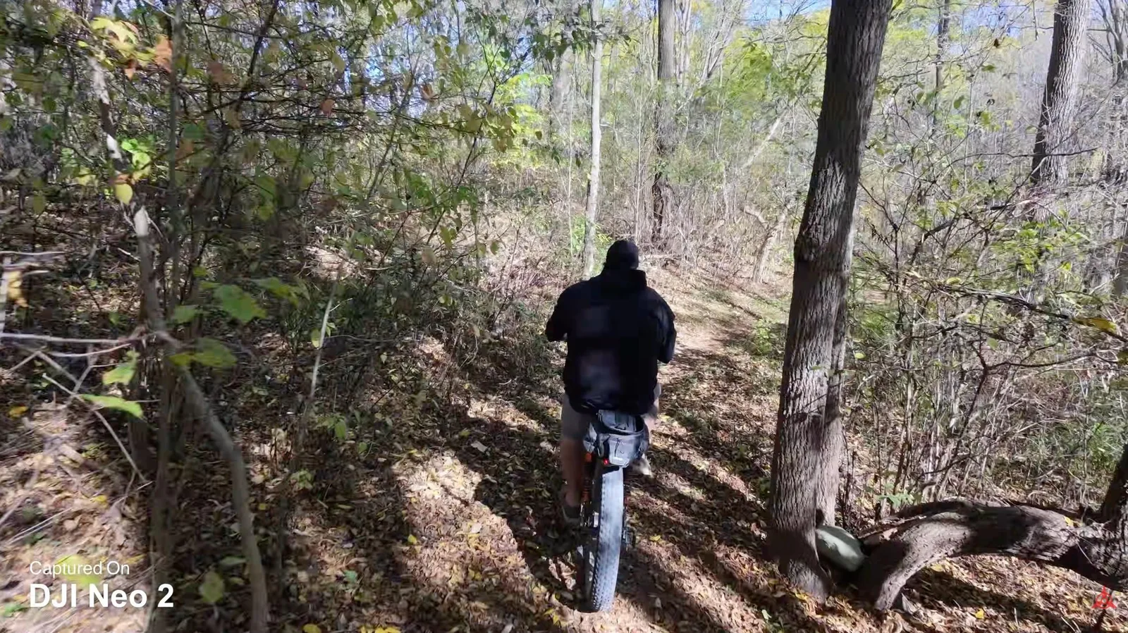 DJI Neo 2 following a mountain biker along a forest trail