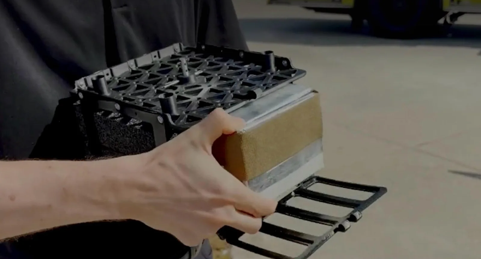 Hand holding the drone's insulated payload module with its bottom hatch open