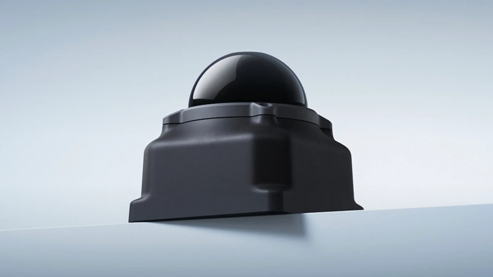 Livox Mid-360L 3D LiDAR sensor, a black square housing topped by a dark hemispherical dome, sitting on a pale grey ledge