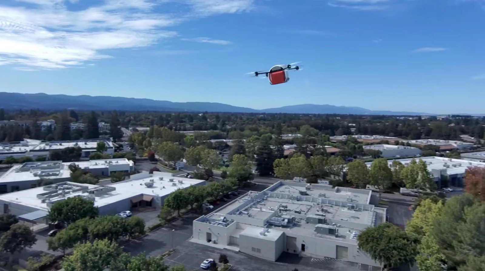 Matternet M3 delivery drone flying over a suburban business park