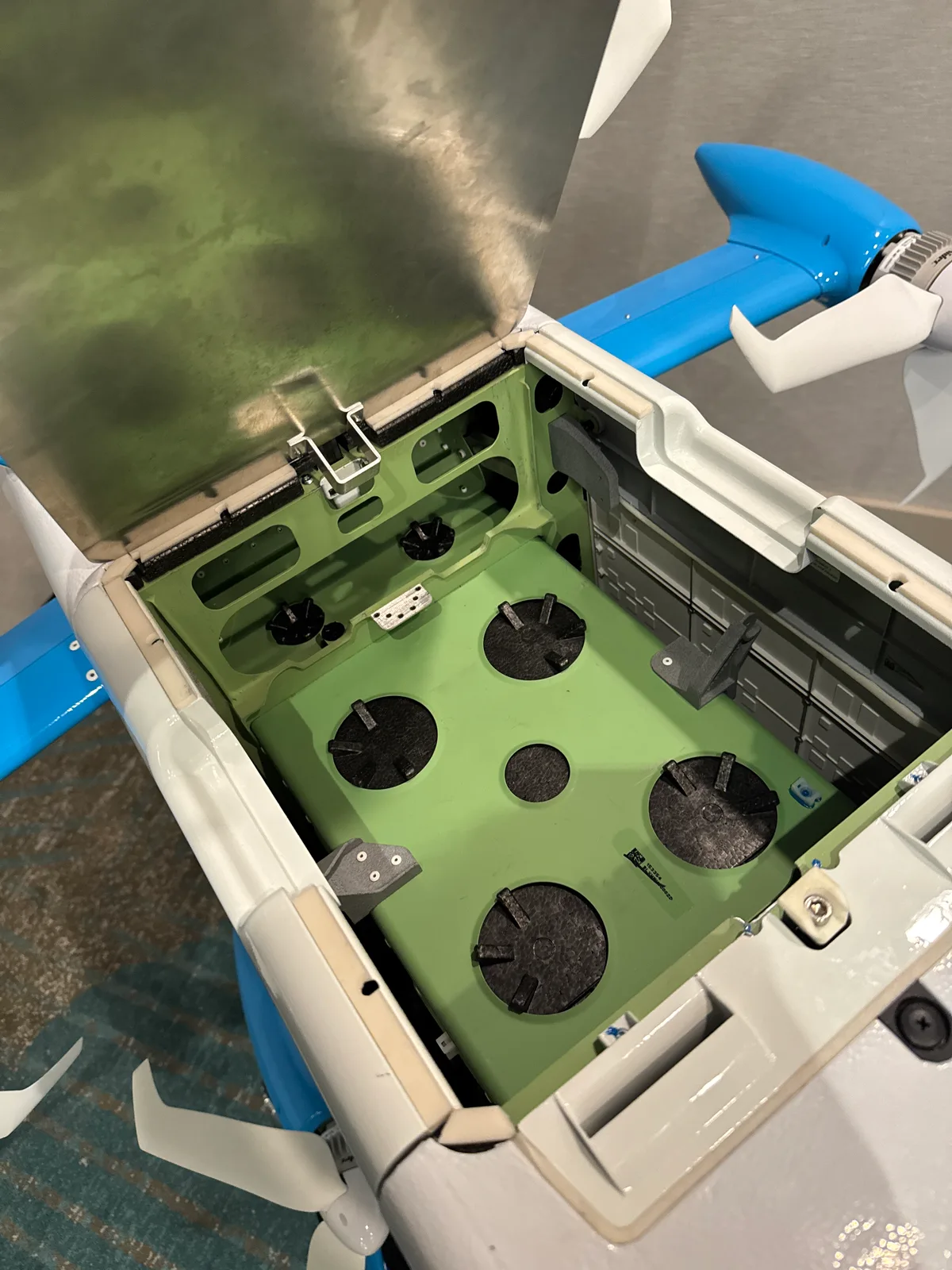 Open hinged hatch on top of the MK30 drone revealing an empty green-primed bay