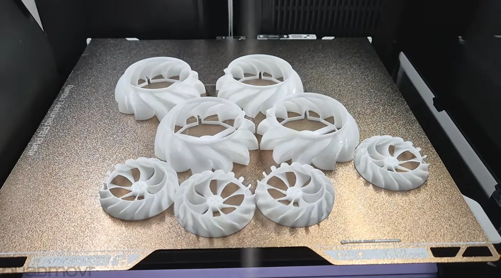 3D printed radial impeller wheels and vaned housings on a printer build plate