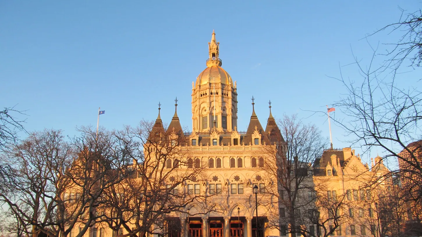 Connecticut State Capitol in Hartford, its gold dome lit by low sun above bare trees