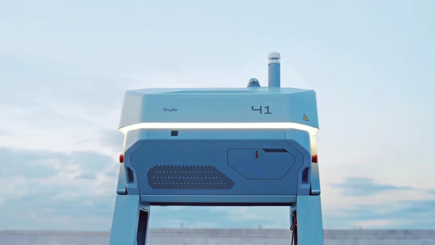 White Skydio Dock for X10 station with its lid closed and the number 41 on the side, photographed against a pale blue sky