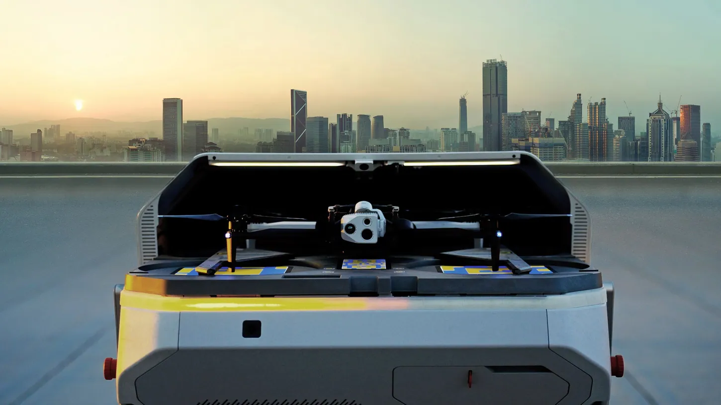 Open Skydio Dock for X10 on a rooftop with a Skydio X10 drone sitting inside it and a city skyline at sunrise behind